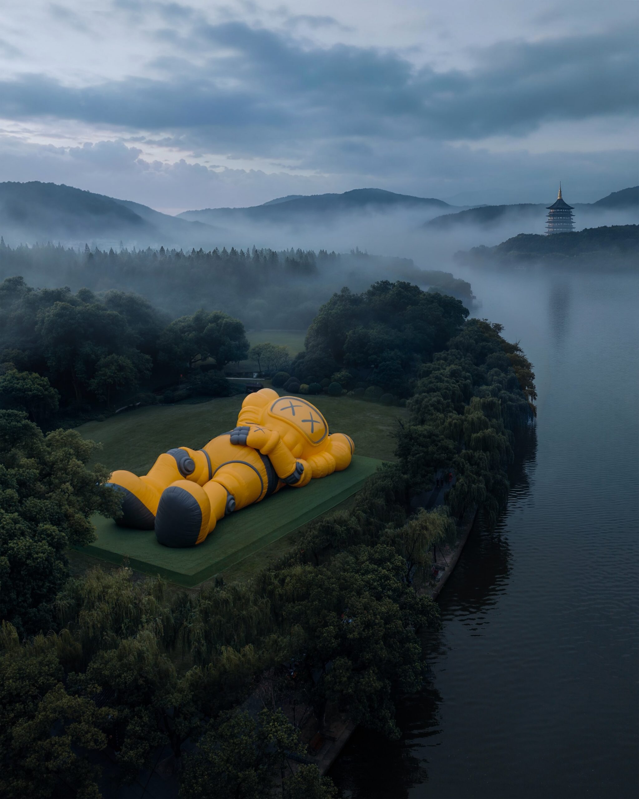 Aerial view of the installation by the lake, Leifeng Pagoda rising out of the mist across the water
