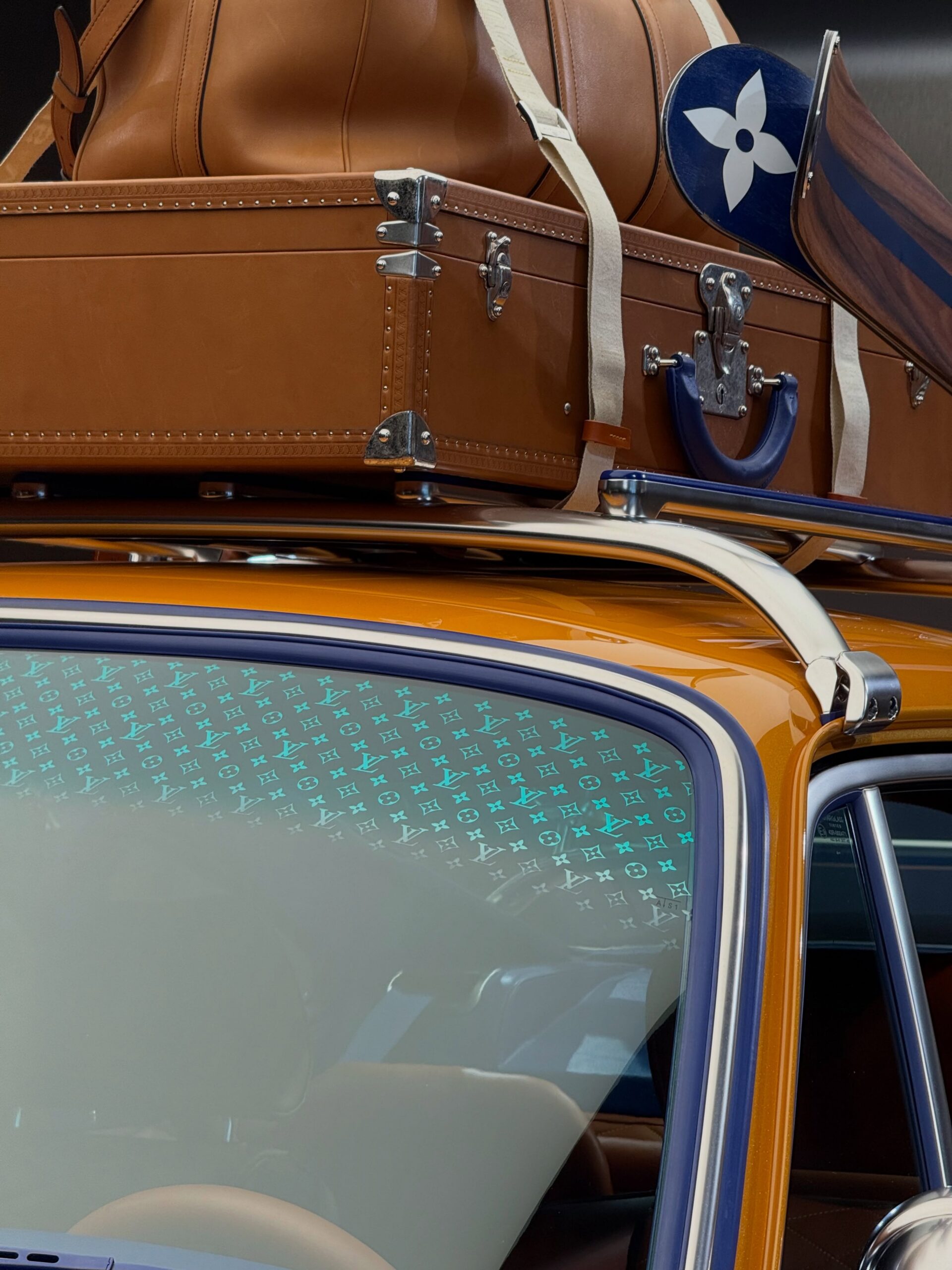 Close-up of monogram etched windshield with LV trunk and blue paddle